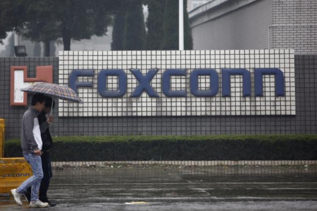 Pedestrians walk past an Foxconn factory complex located in Kunshan, Jiangsu Province, China, 31 March 2012. Photo: EPA