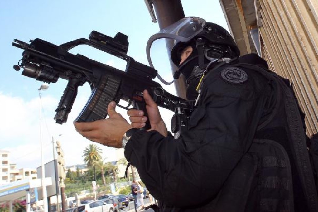 A French policeman stands guard in front of a building as anti-terrorist operations are conducted.  Photo: AFP