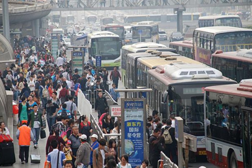 Returning from a long holiday, passengers wait for their buses amid a haze in the air on Sunday at West Railway Station in Beijing. Photo: Xinhua