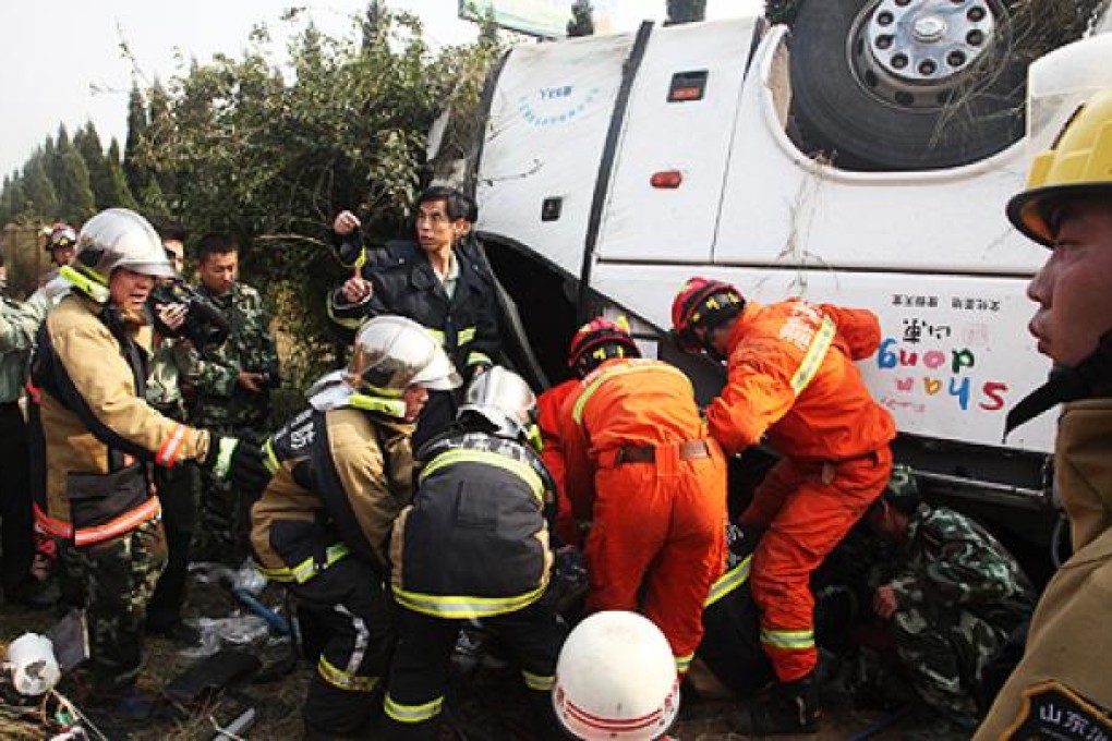Rescuers try to help passengers involved in a bus accident on the Zibo section of the Qingdao-Yichuan expressway in eastern Shandong province on Sunday. Photo: Xinhua