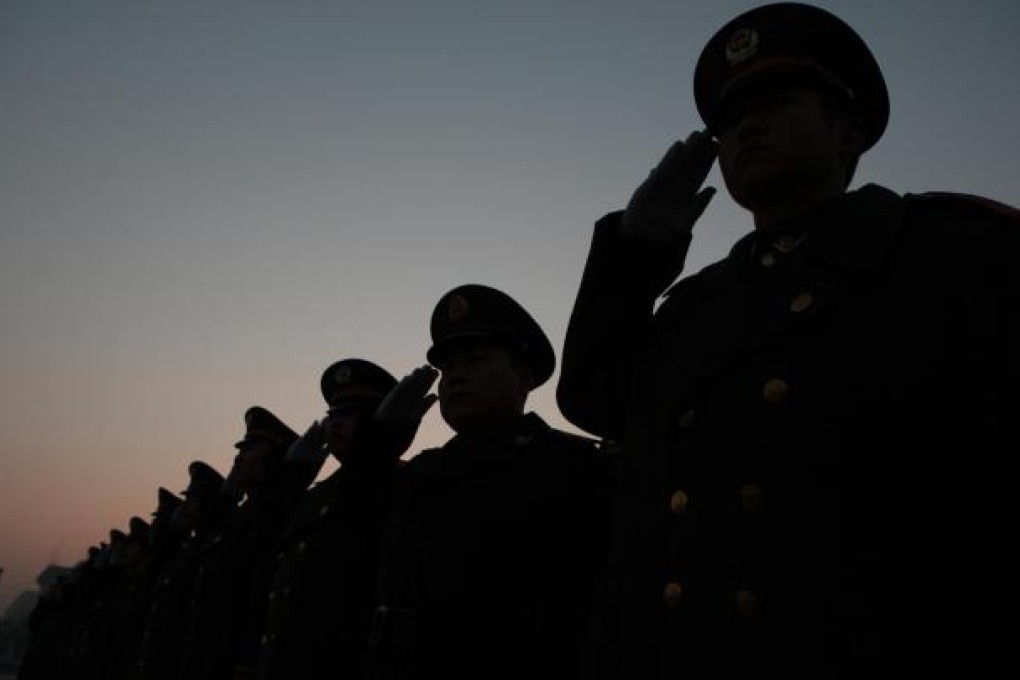 Soldiers of the Chinese People's Armed Police salute the national flag in Tiananmen Square in Beijing. The PLA's growing lack of transparency is 'hindering efforts to build international trust'. Photo: Xinhua