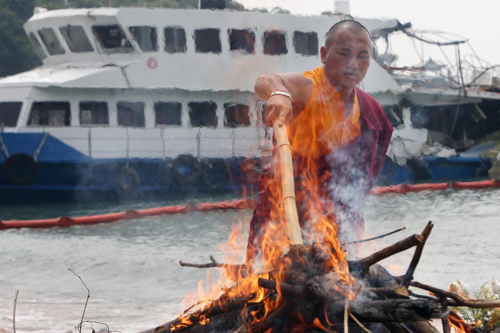 A Buddhist monk performs a ritual on Lamma Island to honour the victims yesterday. Photo: Sam Tsang
