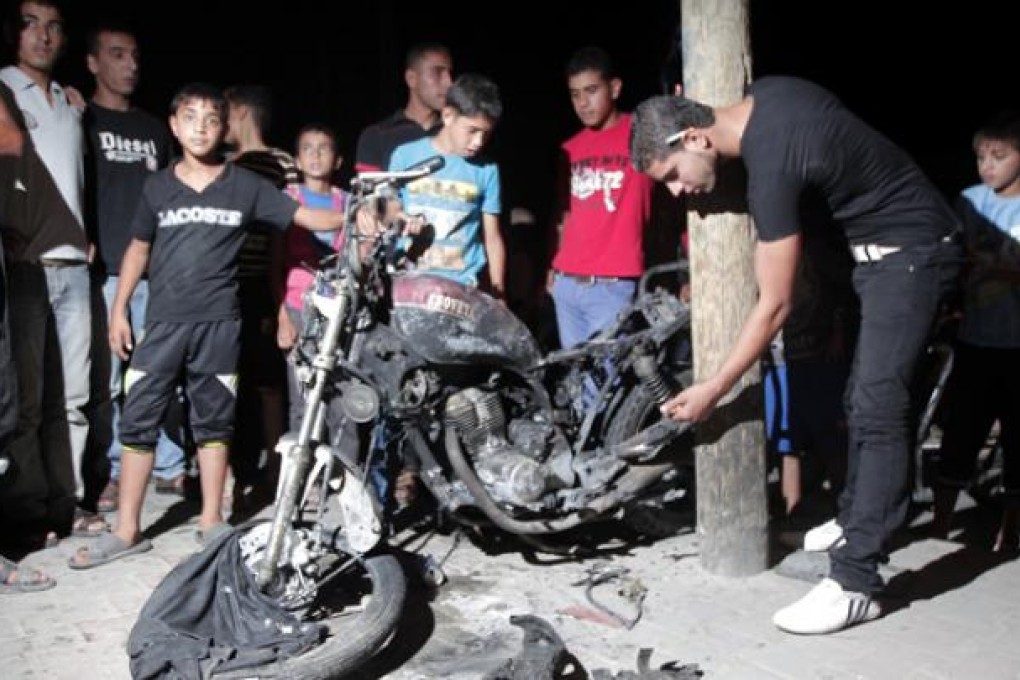 Palestinians inspect a destroyed motorbike following an Israeli aerial bombing in the southern Gaza Strip city of Rafa on Sunday. Photo: Xinhua