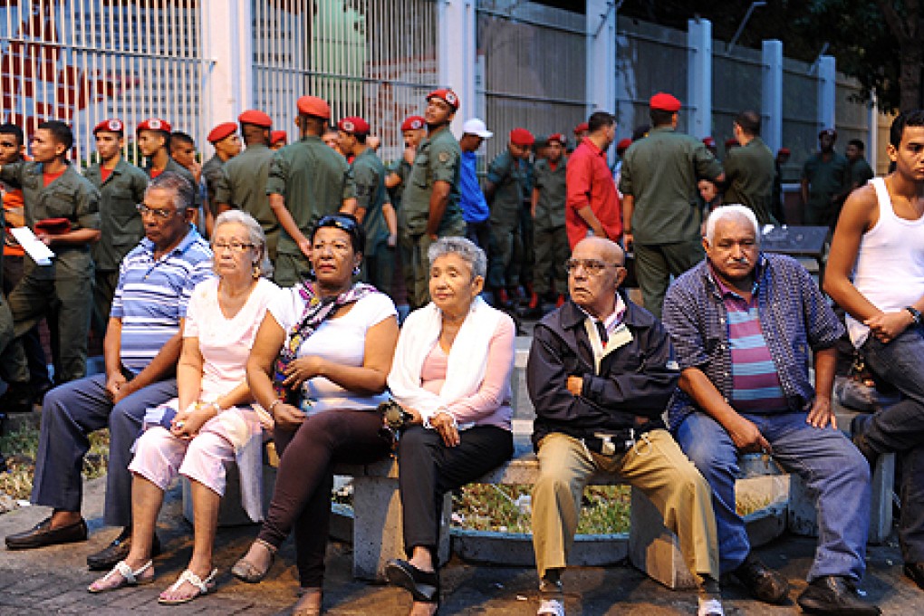 Venezuelans wait outside a polling station before voting in Caracas on Sunday. Photo: AFP
