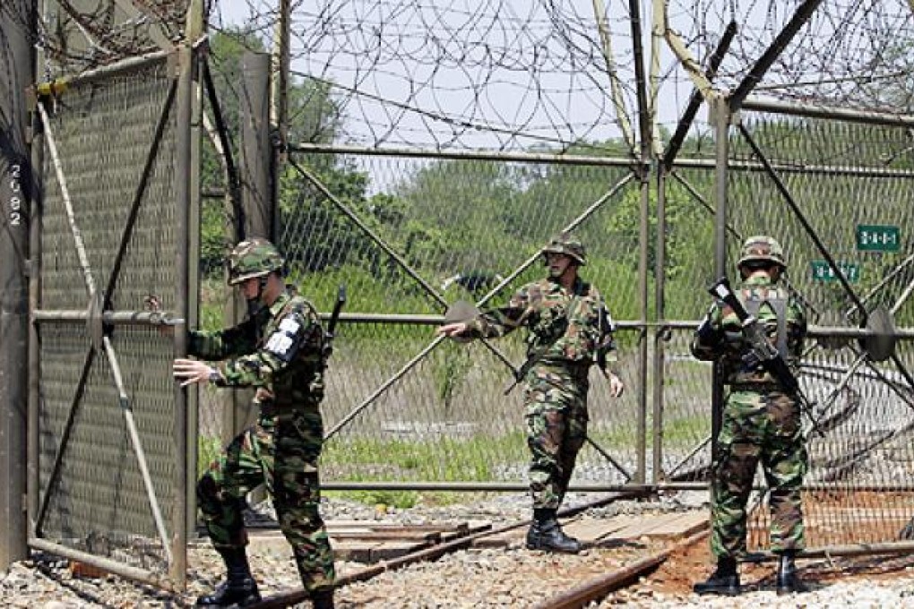 South Korean soldiers open a gate for a train to pass close to the demilitarized zone in South Korea. Photo: AFP