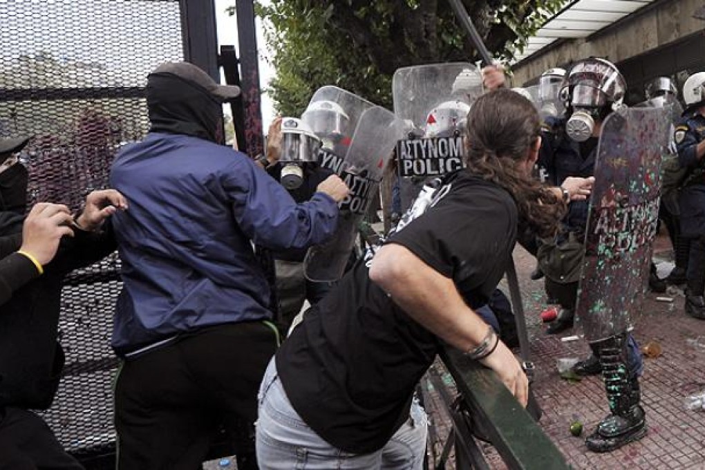 Protesters clash with riot police protecting the Greek parliament in Athens during a demonstration against the visit of the German Chancellor Angela Merkel. Photo: AFP