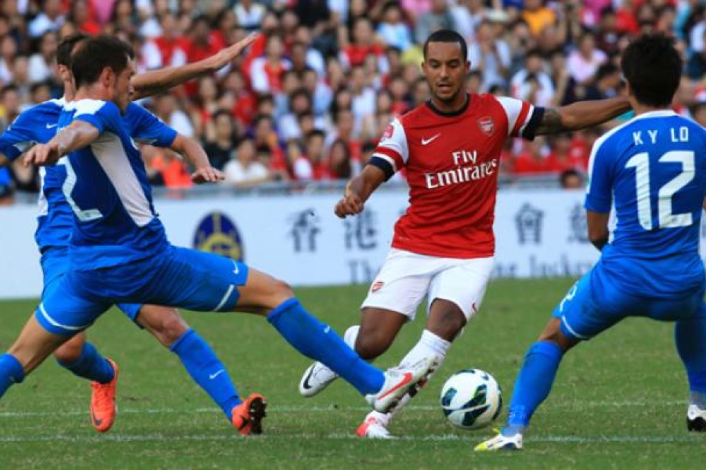 Kitchee players surround Arsenal's Theo Walcott at their friendly match at Hong Kong Stadium in July. Photo: Jonathan Wong