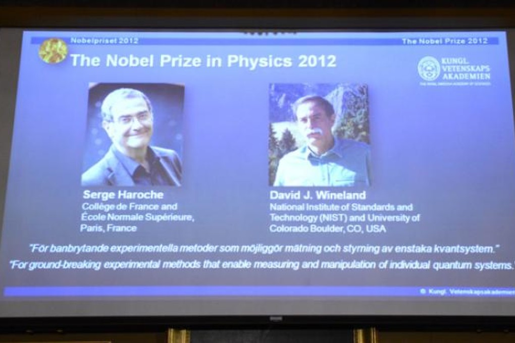 Pictures of Serge Haroche and David Wineland are projected on a screen on Tuesday at the Royal Swedish Academy of Science in Stockholm. Photo: AFP