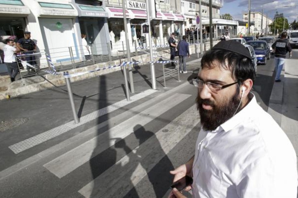 A man outside the grocery in Sarcelles, in northern Paris, which was attacked by suspected "jihadists" on Wednesday. Photo: AP