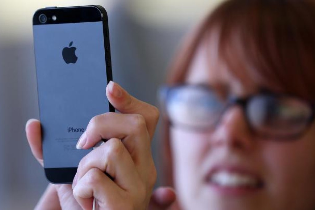 A potential buyer takes a closer view of the new iPhone 5. A record five million units were sold on the weekend of its debut. Photo: AFP