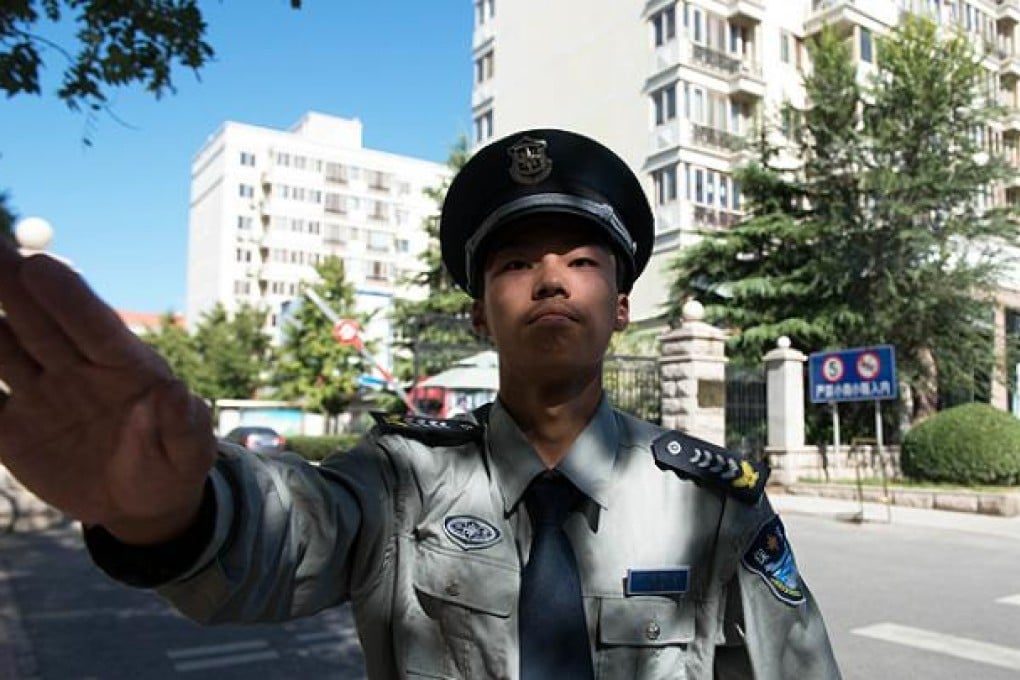 A security guard prevents a photographer from taking photos outside Liu Xiaobo's apartment in Beijing on Wednesday. Photo: AP