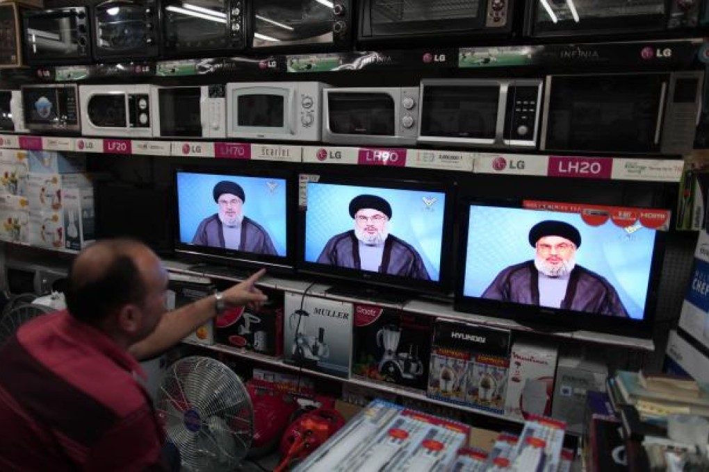 A Palestinian man in a shop in Gaza watches Hezbollah leader Hassan Nasrallah's speech, broadcast by the group's Al-Manar TV. Photo: Xinhua
