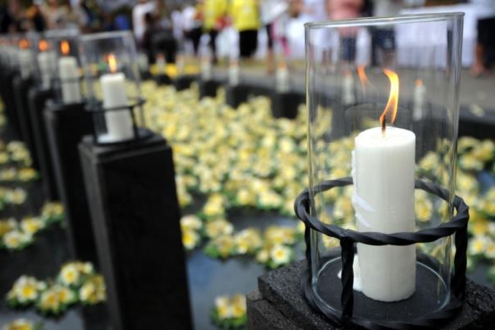 Survivors and relatives of victims of the October 12, 2002 Bali bombings lay flowers at the pool of remembrance during a ceremony marking the 10th anniversary of Bali bombings at the Garuda Wisnu Kencana cultural park in Jimbaran, Bali, Indonesia. Photo: AFP