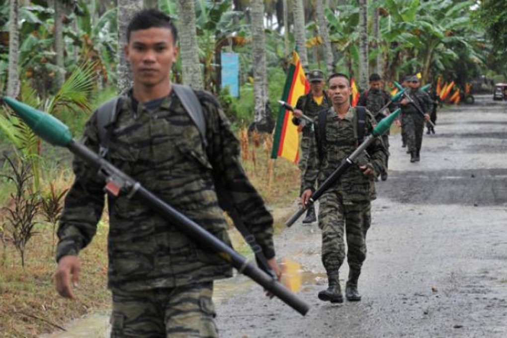 MILF rebels carrying rocket propelled grenades patrol inside their base at Camp Darapan, Sultan Kudarat province, Mindanao. Photo: AFP