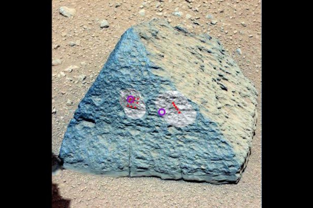 A handout photo provided by NASA on 11 October 2012 and taken by the Curiosity rover's right Mast Camera (Mastcam-100) on 22 September 2012, shows a rock known as 'Jake Matijevic' with the red dots showing where the Chemistry and Camera (ChemCam) instrument zapped it with its laser. Photo: EPA