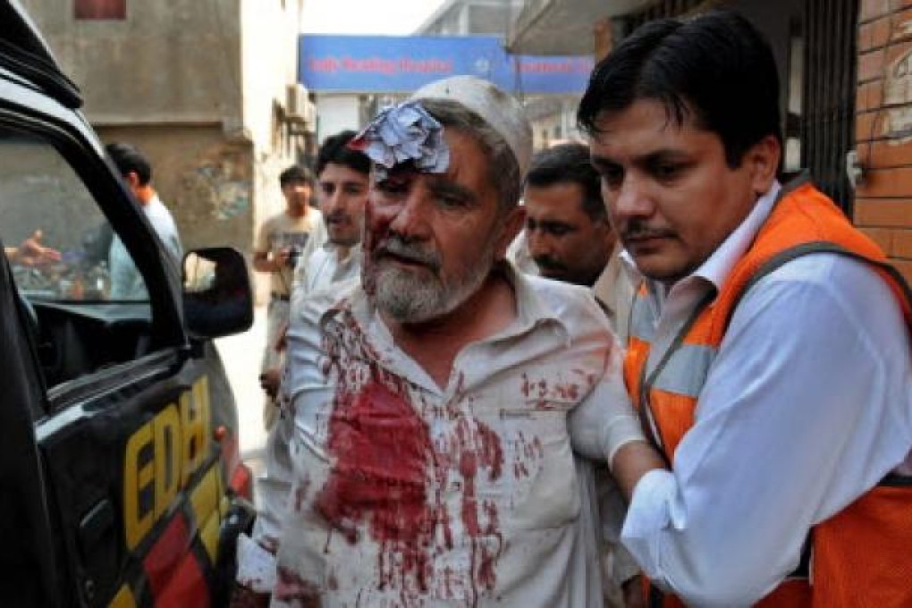 A paramedic helps a victim of a bomb explosion, at a local hospital in Peshawar, Pakistan on Saturday.. At least 15 people were killed in the attack. Photo: EPA
