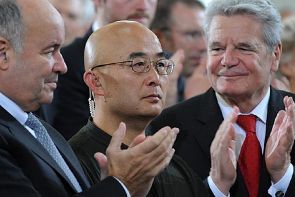 Liao Yiwu (centre) collects the German Book Trade Peace Prize in Frankfurt on Sunday. Photo: EPA