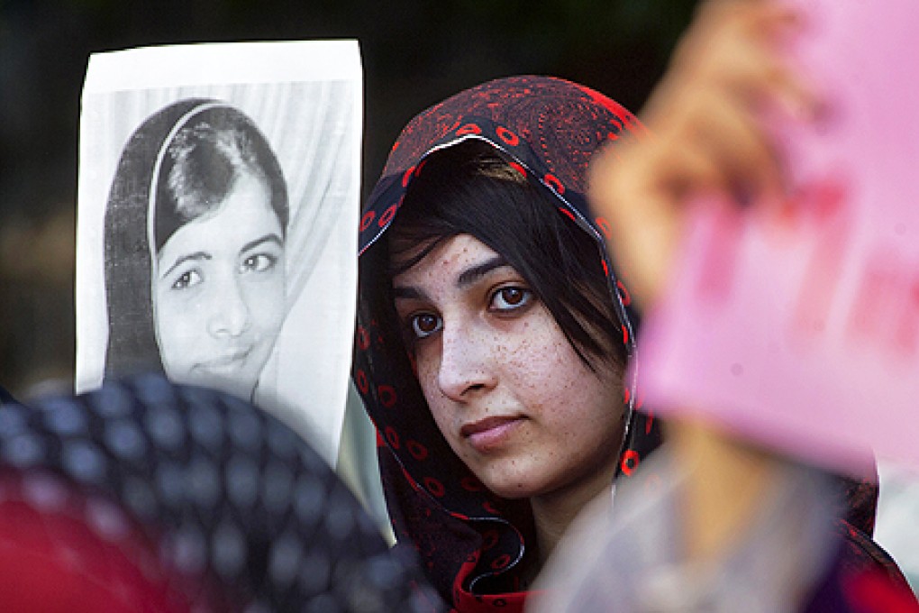 A protester holds up a photo of Malala Yousufzai at a demonstration in Islamabad on Saturday. Photo: AP