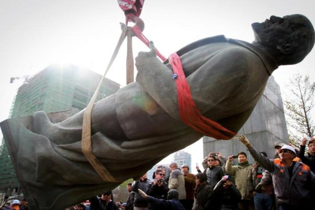 A crowd watches Lenin's statue being taken away. Photo AFP