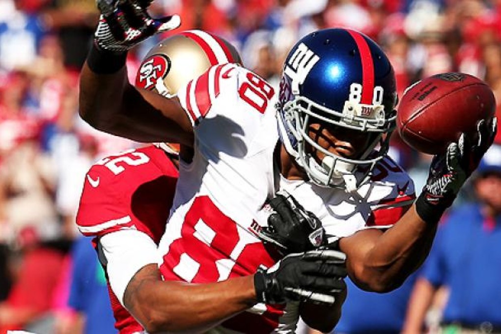 Wide receiver Victor Cruz of the New York Giants bobbles a pass against Carlos Rogers of the 49ers on Sunday. Photo: AFP