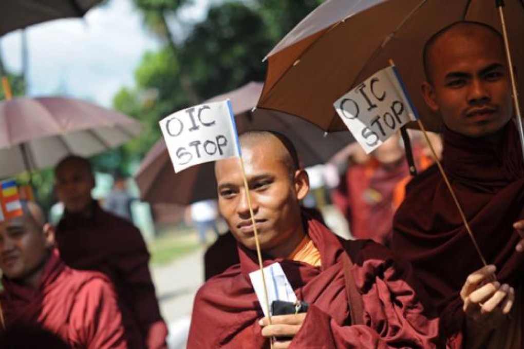 Myanmar Buddhist monks hold signs as they take part in a demonstration against the Organisation of the Islamic Conference in Yangon on Monday. Photo: AFP