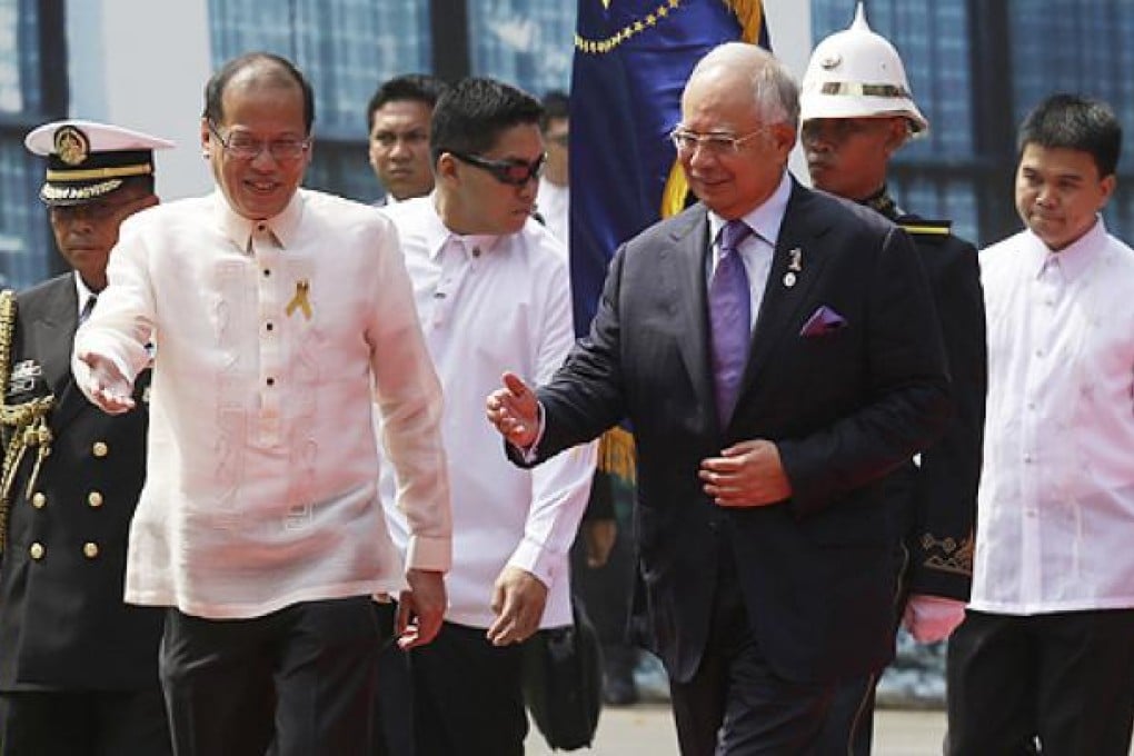 Philippine President Benigno Aquino welcomes Malaysian Prime Minister Najib Razak, who arrived in Manila to witness the landmark signing. Photo: AP