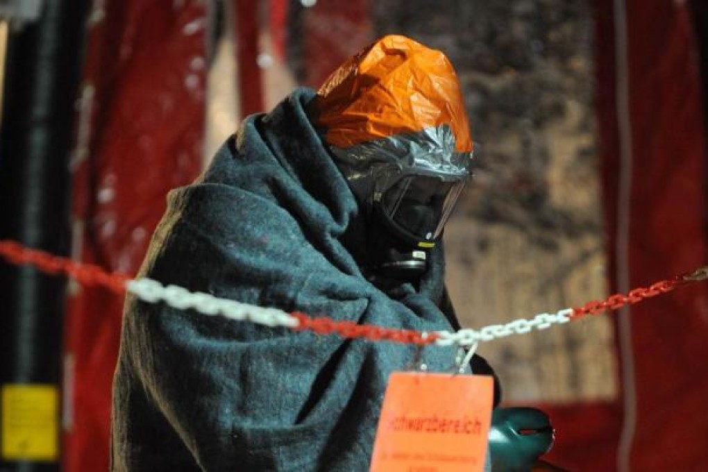 A woman feels the effects of fumes at the factory. Photo: AFP