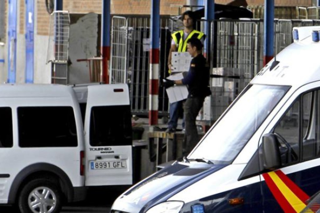 Spanish National Police agents collect documents found after they raided a Chinese business at the Cobo Calleja industrial estate, in Fuenlabrada district, Madrid, on Tuesday. Photo: EPA