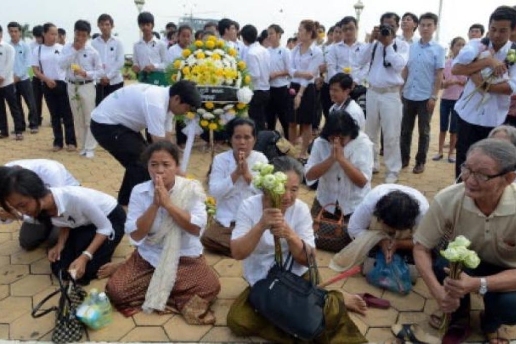 Cambodian people pray for the late former King Norodom Sihanouk in front of the Royal Palace in Phnom Penh on Tuesday. Photo: AFP