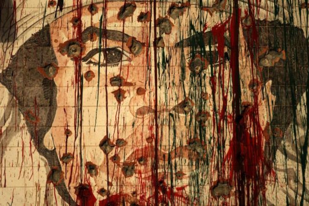 A defaced mural of Muammar Gaddafi shows the public mood, but now the tide is also turning against those who overthrew him. Photo: AFP