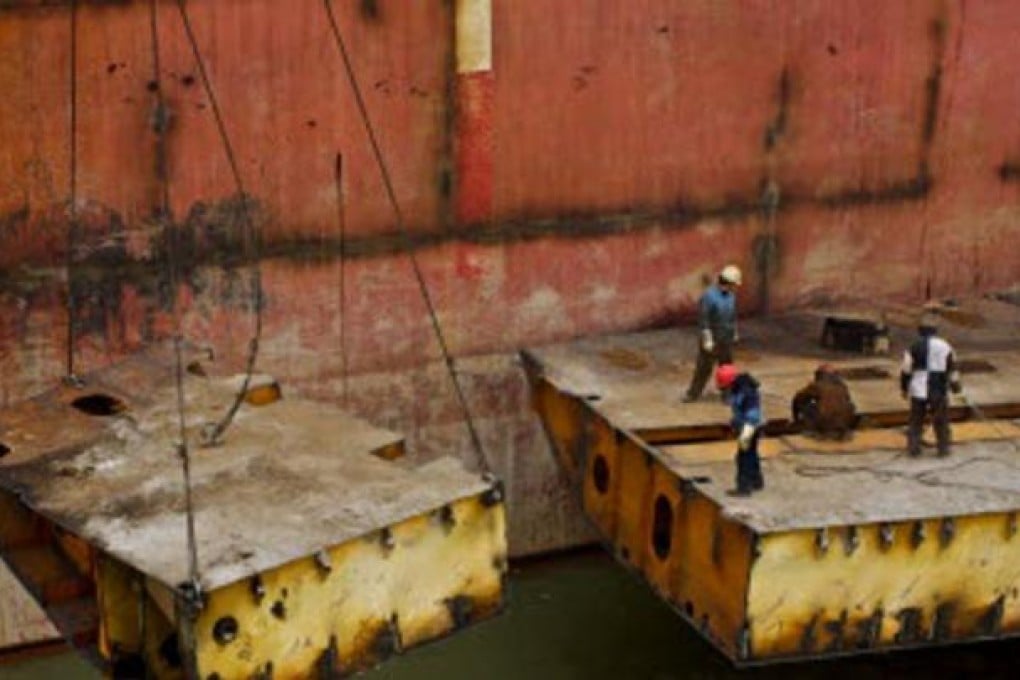The final stages of recycling, double bottom sections are removed while the next ship is alongside.