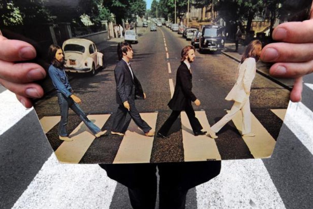 A Beatles tour guide holds his copy of the Beatles' Abbey Road album in Abbey Road, the one in St John's Wood that is. Photo: PA