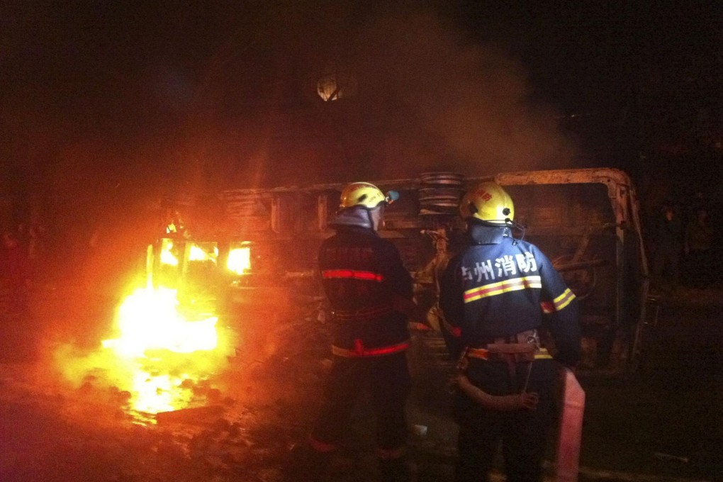 Firefighters try to extinguish a fire in an overturned police car in Luzhou, Sichuan province, on Wednesday. Photo: Reuters