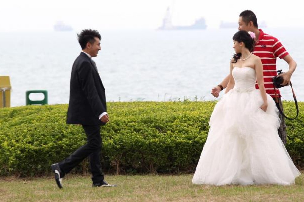 A couple have their wedding photos taken in the waterfront park. Photo: Dickson Lee