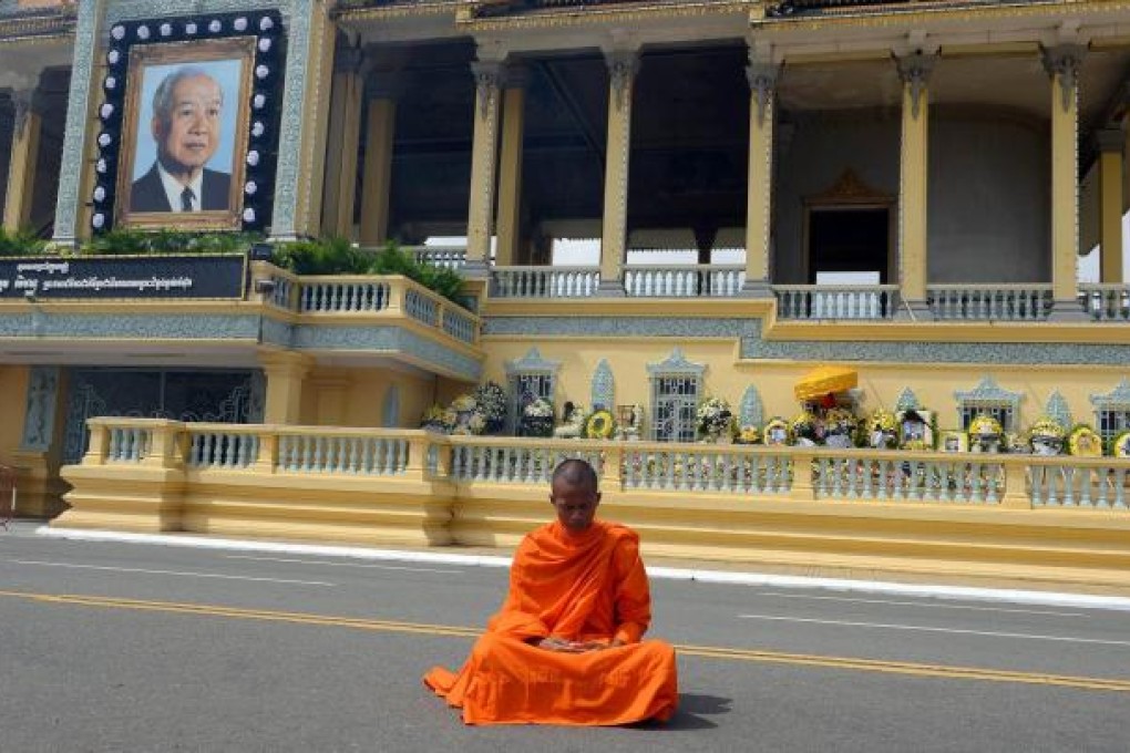 A monk prays as he grieves for Norodom Sihanouk. Photo: AFP