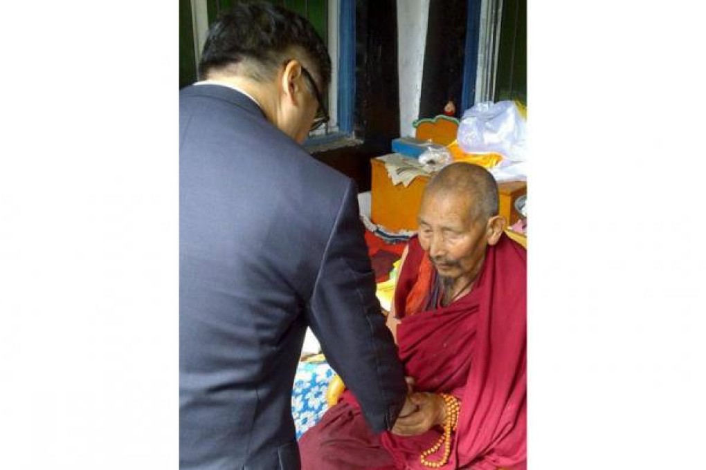 US envoy Gary Locke shakes hands with a Tibetan monk.