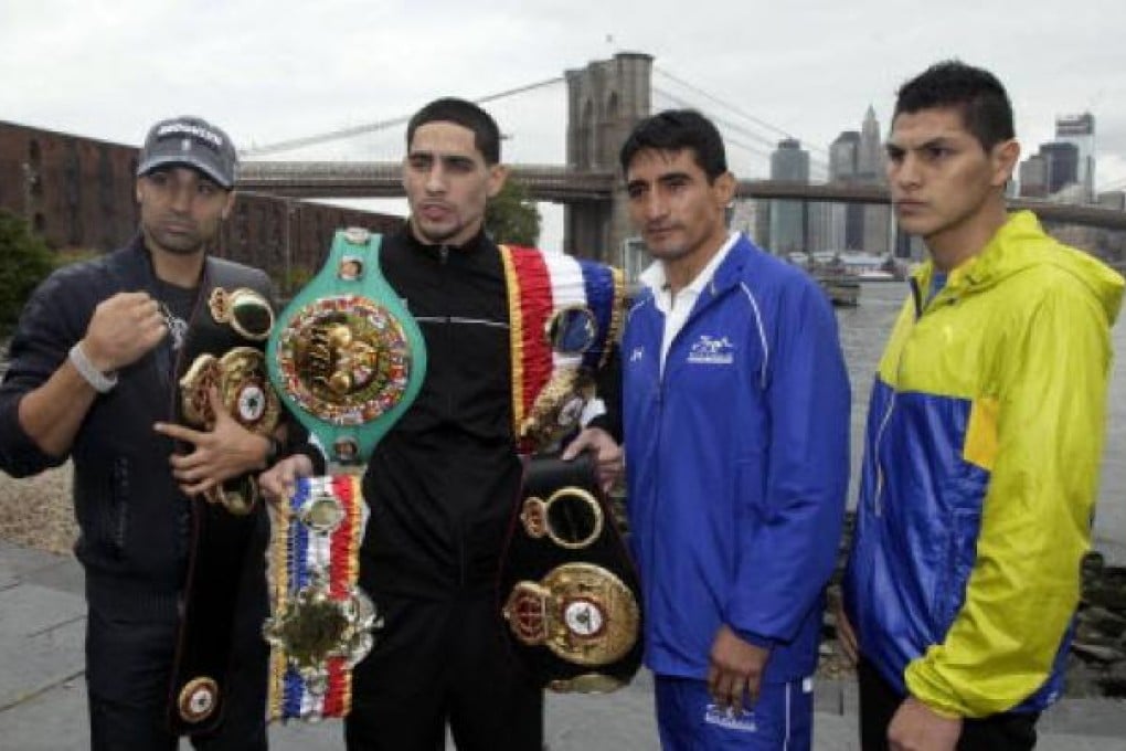 Boxer Danny Garcia, second left, from Philadelphia, the current Ring Magazine, WBC and WBA Super Lightweight Champion, wears his belts, as he poses for photos with opponent Erik Morales, of Tijuana, Mexico, third left, near the Brooklyn Bridge, in the Brooklyn borough of New York. Photo: AP