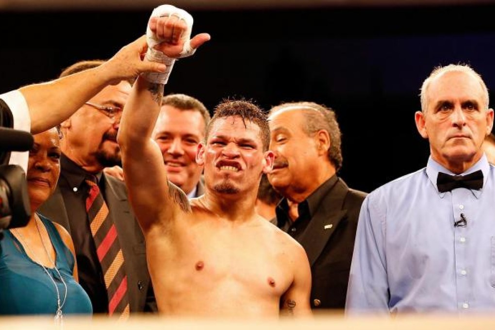Gay boxer Orlando Cruz has his arm raised in victory after gaining a unanimous decision over Jorge Pazos in Florida. Photo: AFP