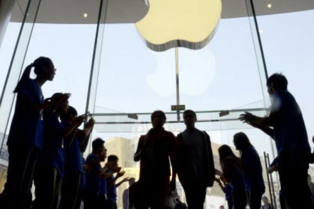 Apple staff welcome customers in the new Apple store at WangFujin business district in Beijing on October 20,2012. Photo: AFP