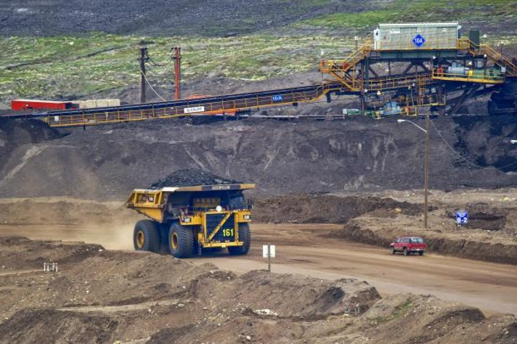A truck carries its load at the Syncrude Canada oil sands North Mine in Alberta, a venture involving China investment. Photo: Bloomberg