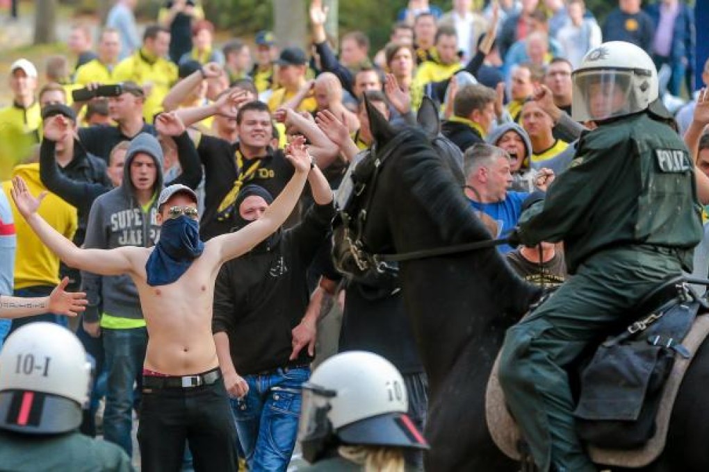 Dortmund fans face riot police before the match against Schalke. Fans of the rival clubs clashed before the game. Photo: EPA