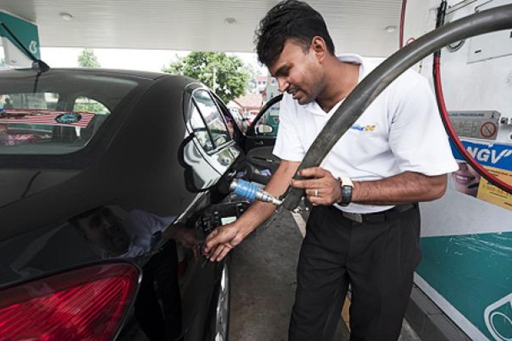 A worker refuels a vehicle in Kuala Lumpur. Canada has blocked Malaysian state oil firm Petronas’ bid for gas producer Progress Energy Resources. Photo: AFP