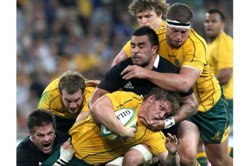Australia's Pat McCabe (front) is tackled by New Zealand's Liam Messam during the Bledisloe Cup match in Brisbane. Photo: AP