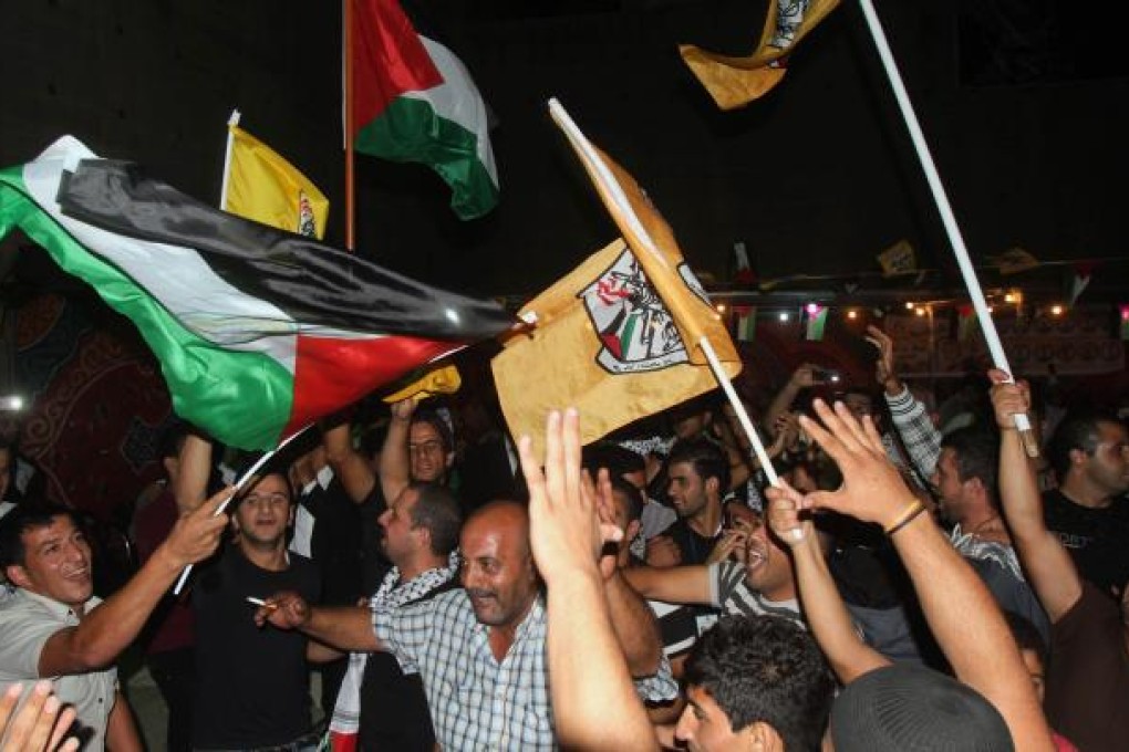 Palestinian Fatah supporters wave Fatah and national flags as they celebrate in the West Bank city of Bethlehem. Photo: AFP
