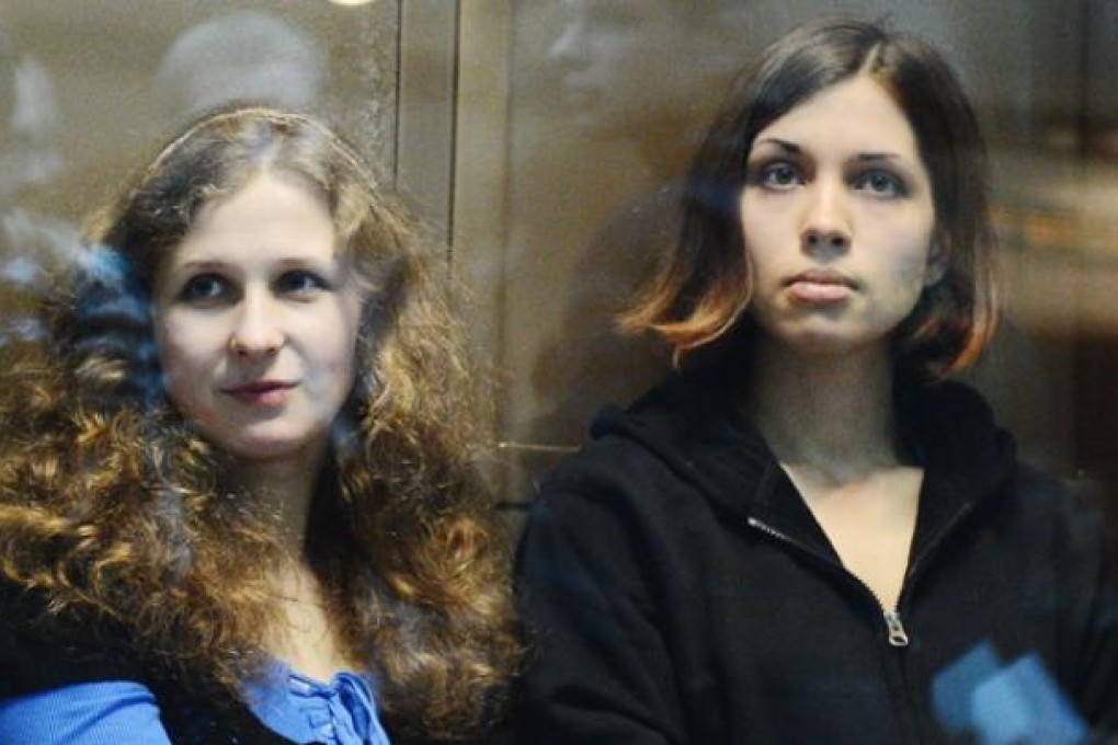 Maria Alyokhina and Nadezhda Tolokonnikova sit in a glass-walled cage in a court in Moscow on October 10. Photo: AFP