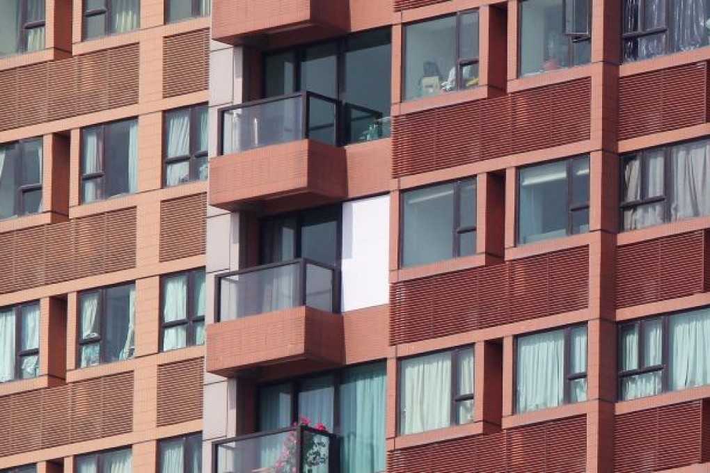 A white cover masks a broken window at The Arch in West Kowloon. Residents fear the breakages will reduce the value of their flats. Photo: Felix Wong