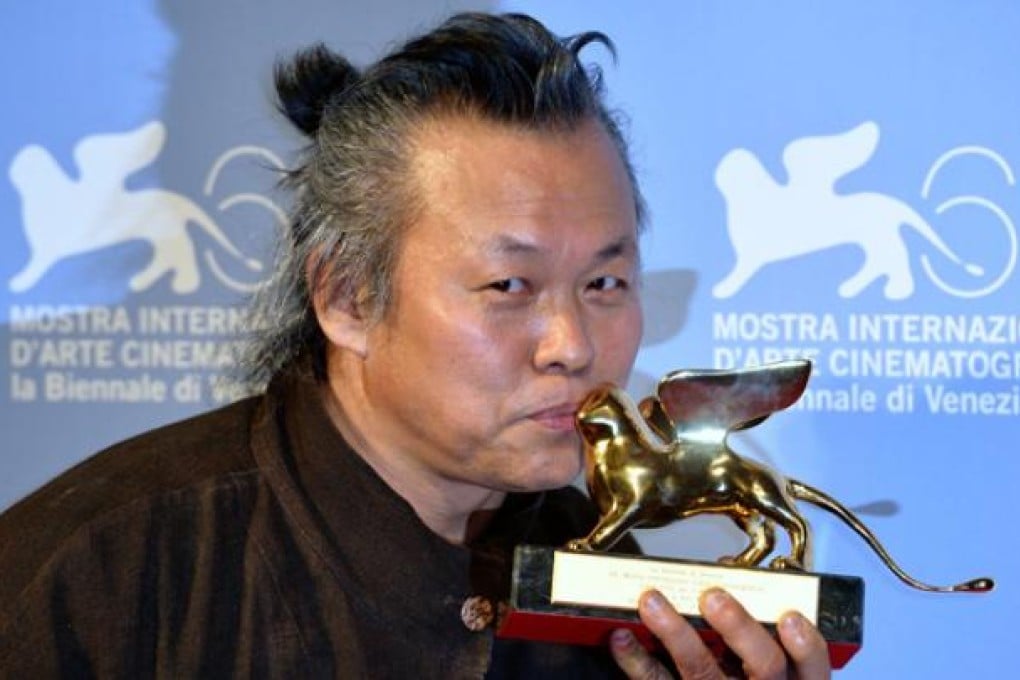 South Korean director Kim Ki-duk kisses the Golden Lion for Best Film for his film <i>Pieta</i> at the Venice International Film Festival on September 8. Photo: Xinhua