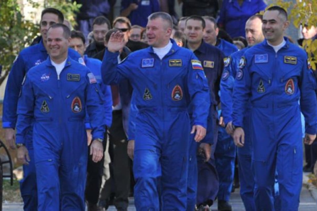 Crew members (left to right) US astronaut Kevin Ford and Russian cosmonauts Oleg Novitskiy and Evgeny Tarelkin walk to a bus during a sending-off ceremony in the Russian-leased Baikonur cosmodrome on Tuesday. Photo: AFP