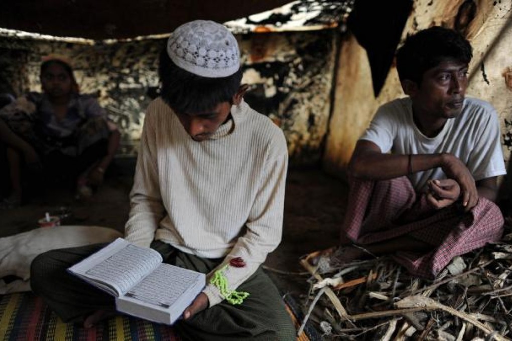 Rohin Mullah reads the Koran in his tent at the Dabang camp, set up for people displaced by the sectarian unrest. Photos: AFP