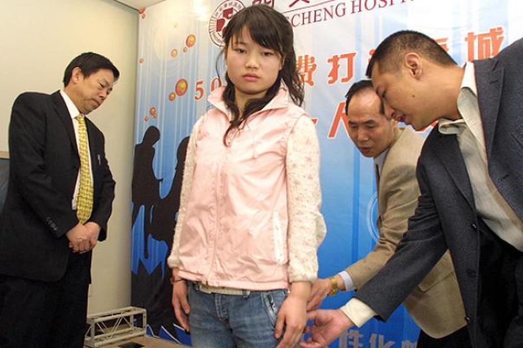 Judges inspect a contestant for a beauty competition in Xian where winners receive 500,000 yuan worth of cosmetic surgery. Photo: AFP